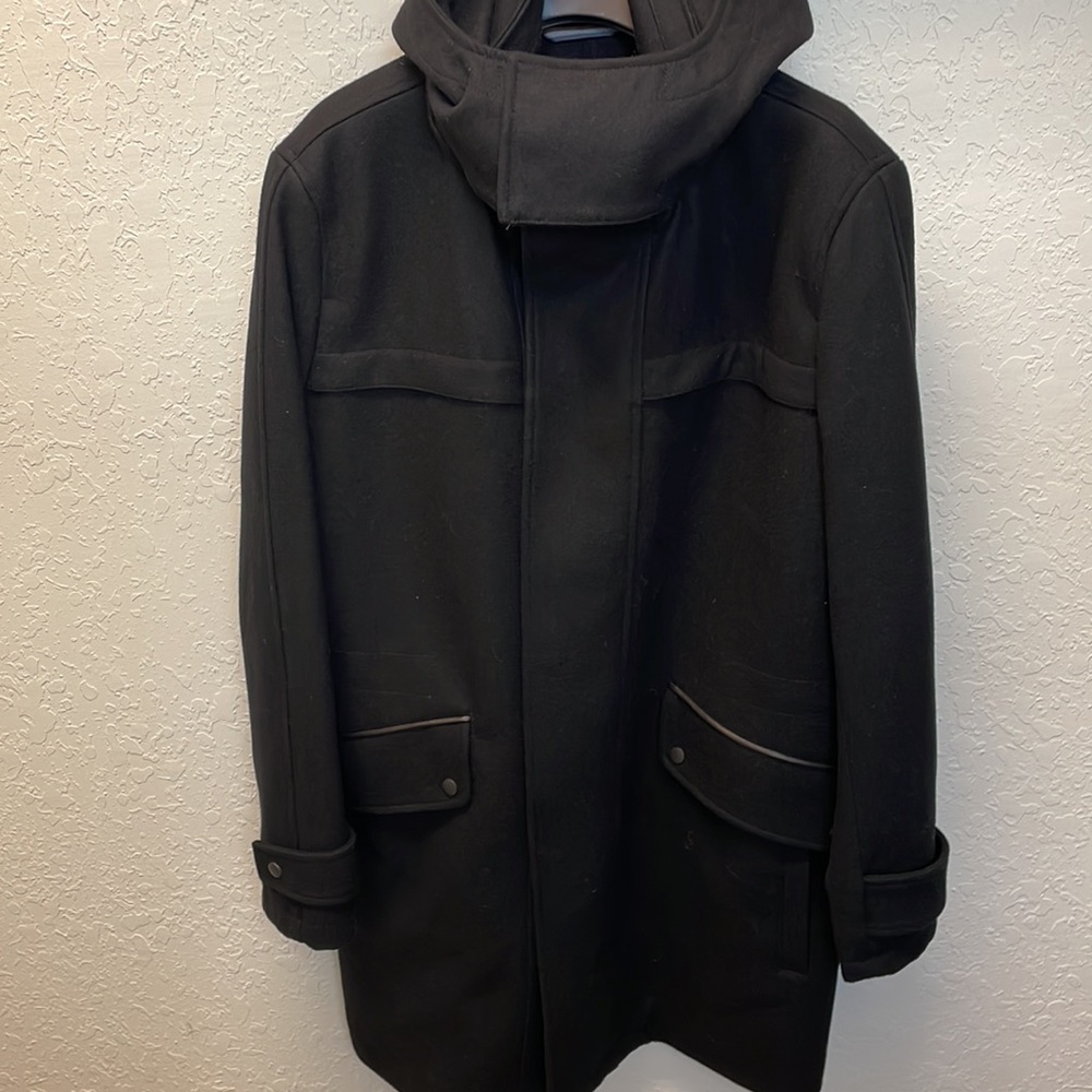 Black zip, wool coat. With leather trim. Removable hood. Inside pull. Pockets.